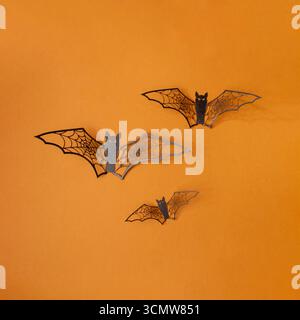 Halloween bats fly on orange background. Copy space invitation card Stock Photo