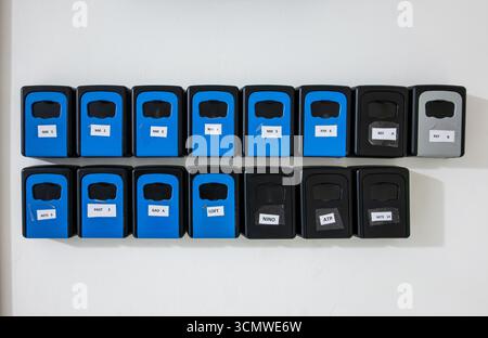 Row of keyboxes key boxes keysafes key safes safety boxes for keys for AirBNB apartments flats holiday lets rentals in the hallway of a building Stock Photo