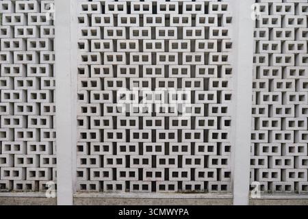 A textured wall featuring a geometric pattern of white blocks arranged in a grid-like formation Stock Photo