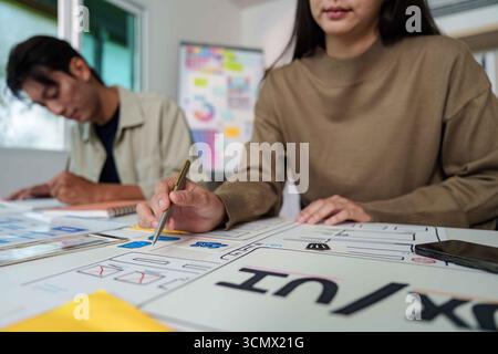Focused UX UI Designers Collaborating in Modern Workspace Stock Photo