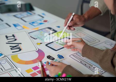 Collaborative UX UI Design. Team Members Working on Mobile App Wireframes and User Interfaces. Stock Photo