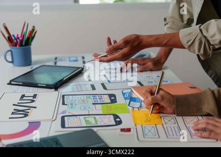 Hands-on UX UI Design. Team members sketching and planning app features. Stock Photo