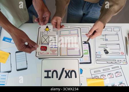 UX UI Design Review. Team evaluating user interface designs and feedback. Stock Photo