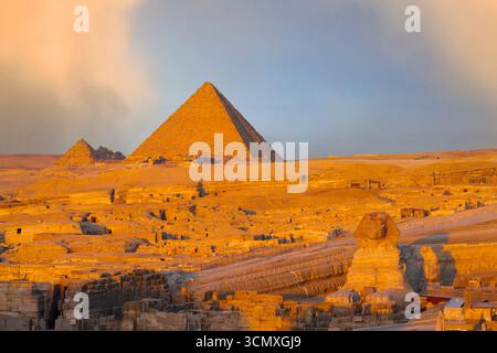 Clouds at dawn over The Sphinx and Giza pyramids, Cairo, Egypt Stock Photo