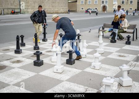 Outdoor chess game with large pieces on Residenzplatz square in historic centre Altstadt of Salzburg in Austria on 11 July 2025 Stock Photo