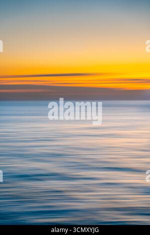 Abstract sea with fluid waves, blending shades of blue, turquoise, and white in a serene, dreamy flow. Stock Photo