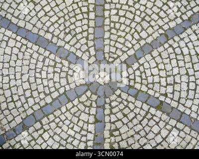 Circular pavement with sun symbol made of gray stones. Historic inspiration. Detailed texture. Copyspace. Stock Photo