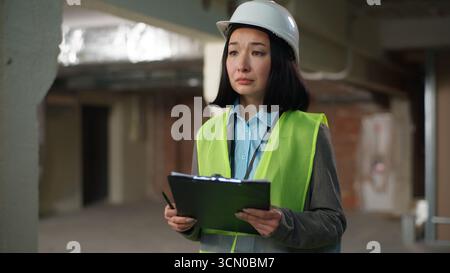 Nervous Asian Korean Japanese woman builder checking documents problem mistake building plan project businesswoman Chinese contractor business female Stock Photo