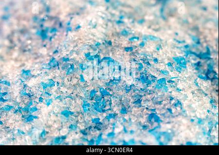 Small pieces of plastic create a colorful and textured background, ideal for industrial or recycling themes Stock Photo