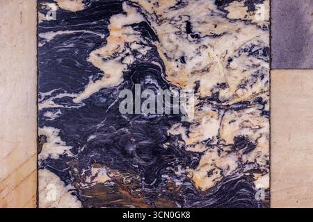 Close-up of an aged and textured marble floor tile featuring dramatic black and white swirling patterns with soft transitions and intricate veining, s Stock Photo