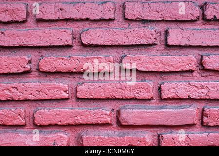 Pink red brick wall with rustic countryside texture, visible mortar lines, and classic abstract background style. Stock Photo