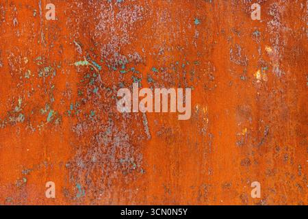 Texture of Rusty orange metal surface with remnants of blue paint, showing signs of corrosion and wear. Stock Photo