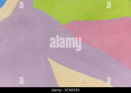 Colorful abstract pattern showcasing a textured wall painted with vibrant pastel hues, including pink, green, yellow, and purple, conveying artistic c Stock Photo