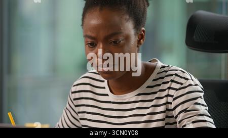 Serious concentrated African American businesswoman ethnic female girl business woman executive manager agent working laptop using corporate Stock Photo