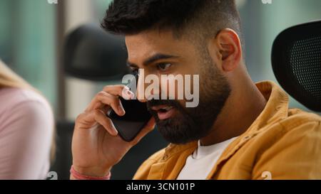 Arabian man informal business guy Hindu businessman Indian male professional talking mobile phone negotiating communicate with smartphone call in Stock Photo
