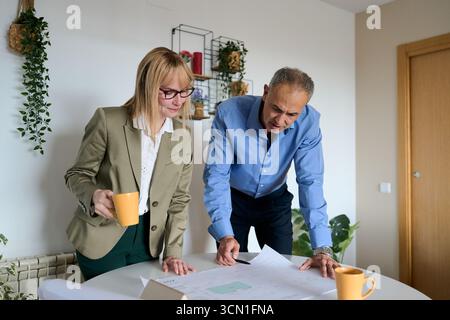 Architects collaborating on building project blueprint in office Stock Photo