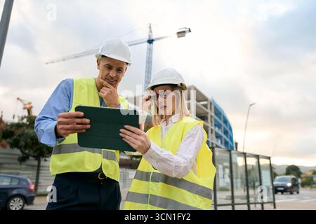 Construction engineers working with tablet on site Stock Photo