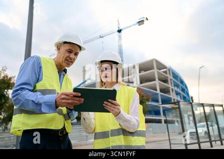 Engineers planning construction project using digital tablet Stock Photo
