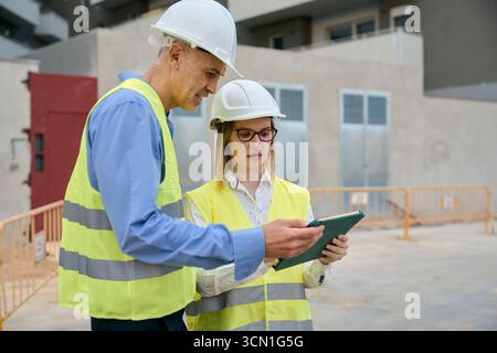 Construction engineers planning project details using tablet Stock Photo