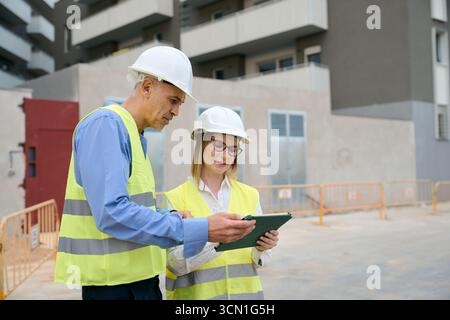 Engineers reviewing construction plans on tablet Stock Photo
