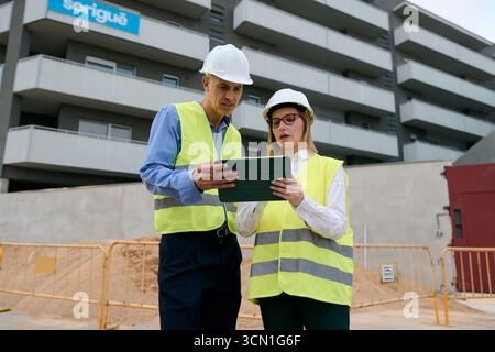 Engineers collaborating on construction site using tablet Stock Photo