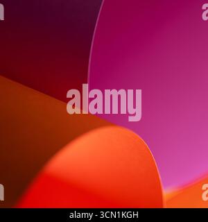 Vibrant Paper Texture Abstract Wallpaper Curved Design. Striking gradient composition in vivid orange, red and pink tones with smooth paper folds. Per Stock Photo
