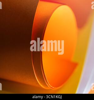 Orange Paper Roll Texture Abstract Wallpaper Background. Warm folded paper shapes with glowing orange and yellow tones create a dynamic minimalist sur Stock Photo