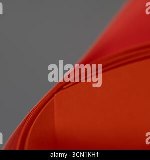 Abstract red orange paper curve background. Minimal geometric composition with folded layers creating a modern texture suitable for design, poster, te Stock Photo