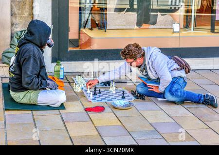 Two men, one homeless, playing chess on the pavement of the Rue Nationale, Tours, Indre-et-Loire (37), France. Stock Photo