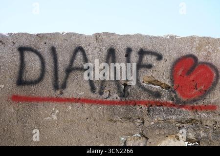 Graffiti on Weathered Concrete Wall With Black Letters and Red Heart Underline. Bonifacio, Corsica, France Stock Photo