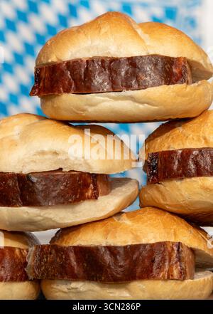 Bavaria, Germany - September 17, 2025: Bavarian snack, meat loaf roll stacked in front of the Bavarian flag *** Bayerische Brotzeit, Leberkässemmel gestapelt vor bayerischer Flagge Stock Photo