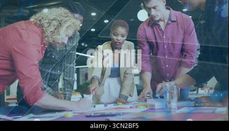 Collaborating team of professionals sketching diagrams at office table, with colored markers. Collaboration, teamwork, brainstorming, innovation, plan Stock Photo
