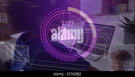 Woman in hoodie monitoring laptop charts in office, showing purple envelope icon with floating code. Technology, cybersecurity, digital, innovation, p Stock Photo