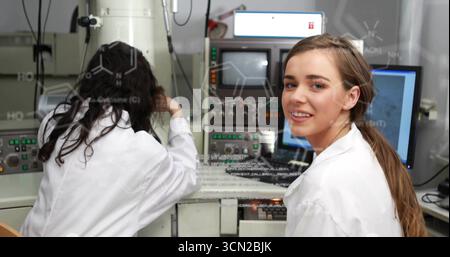Scientist in lab coat adjusting electron microscope at lab bench, chemical overlays, copy space. Research, innovation, technology, analysis, precision Stock Photo