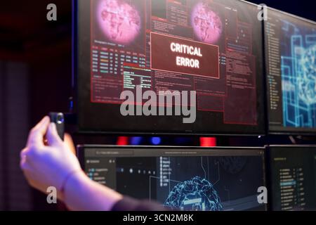 Hacker sees critical error popup on PC after inserting USB stick with malware to breach company servers. Evil man seeing failure alert message when inserting flash drive in computer Stock Photo