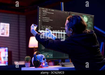 Cybercriminal inserting USB stick in PC with stealth malware that evades security software. Hacker uploading flash drive with script hiding malicious code from detection systems Stock Photo