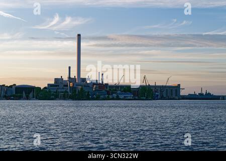From the seaside Stadtwerke Flensburg complex faces the harbor, with tall cranes lining the waterfront and yachts moored nearby. Metal frames, docks a Stock Photo