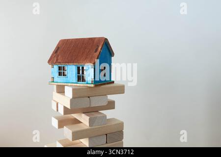 the blocks wood tower game with architectural engineer plans or blue prints compasses ,pencils and ruler on wooden table, plan and building concept. Stock Photo
