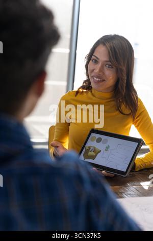 Hispanic designer and african american client showing tablet with room layout at studio Stock Photo