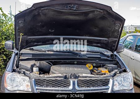 Jumpstart a dead car battery using a power bank in the parking lot Stock Photo