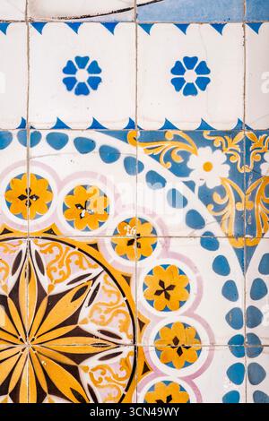 Traditional Portuguese azulejo ceramic tiles showcase intricate blue and yellow geometric and floral patterns on a historic building wall in Porto Stock Photo