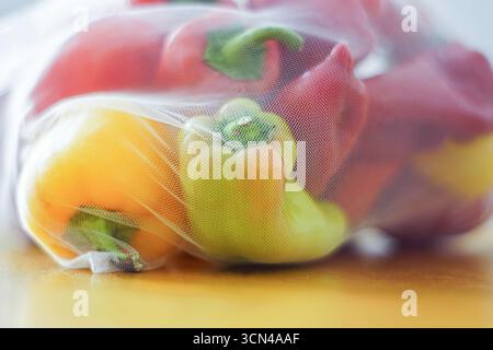 Bright capsicum inside cloth sack. Fresh red and yellow vegetables. Zero waste concept, ethical shopping, organic nutrition, mindful consumer habits Stock Photo