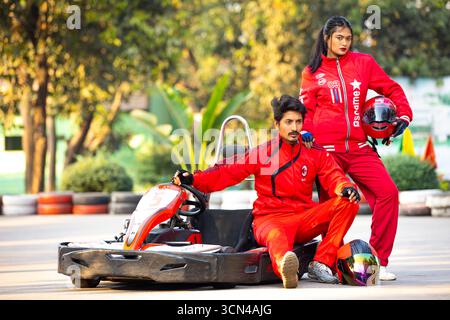 Couple in Racing Gear Posing by Go-Kart - Thrilling Outdoor Adventure Stock Photo