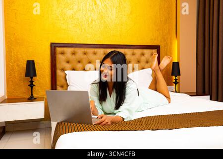 Relaxed Woman Working on Laptop in Bed - Cozy Lifestyle Portrait Stock Photo