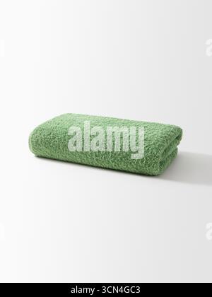 Soft Sage Green Rolled Bath Towel on White Background Stock Photo