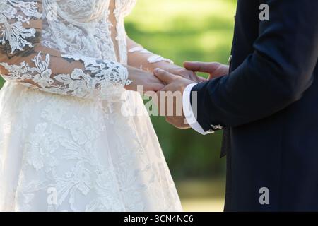 Bride and groom holding hands during wedding ceremony, celebrating their love and commitment Stock Photo