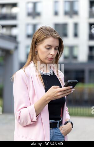 Female professional is using smartphone outdoors Stock Photo