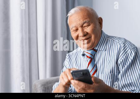 Senior man wearing formalwear and using smartphone Stock Photo