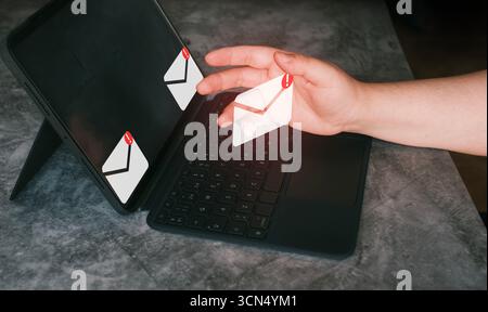Woman use tablet with futuristic interface managing inbox mail. Protect against internet dangers. Junk and trash mail. Compromised information. Stock Photo