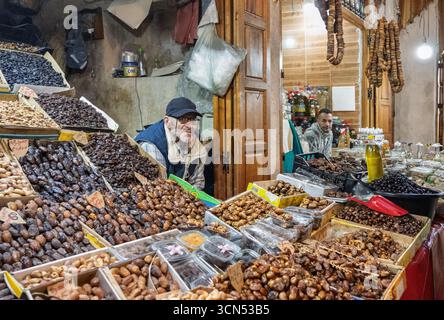 Fez, Morocco, Jan 4 2023, In R’cif market of Fez, a vendor showcases mounds of dates, figs, and nuts in colorful bowls, highlighting the vibrant fruit Stock Photo